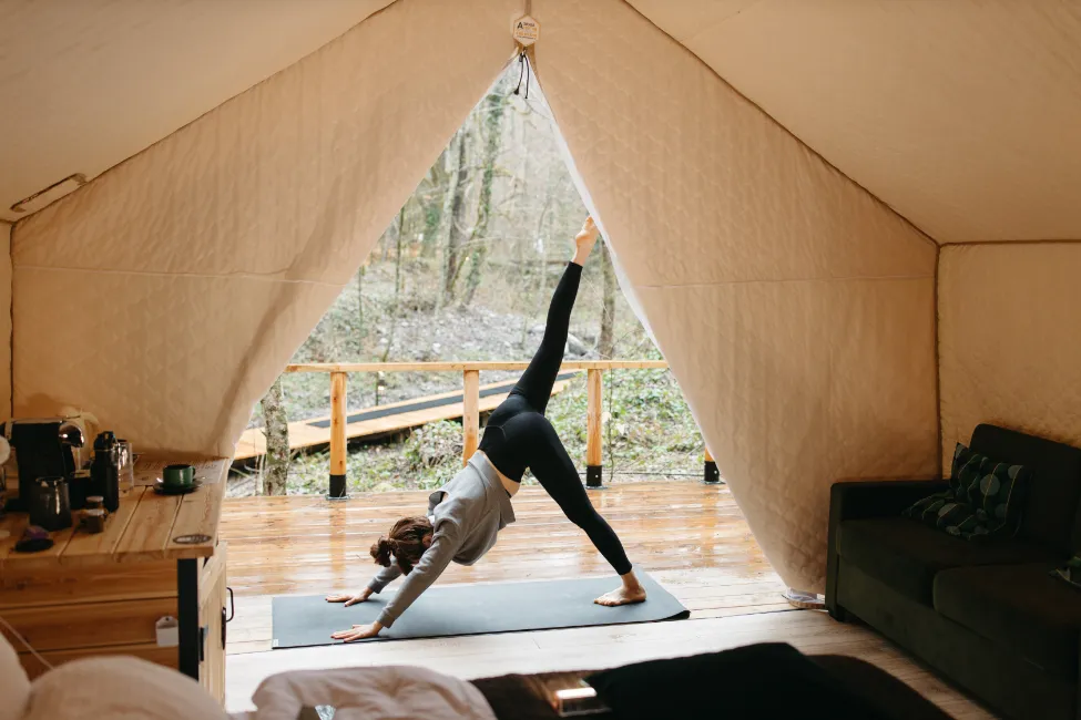 Woman doing yoga in tent - yoga retreat packing list